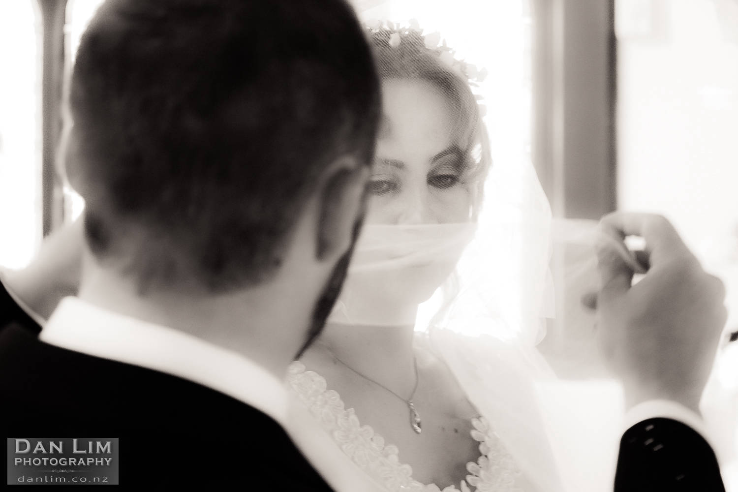 Photograph of Groom lifting the bride's veil.